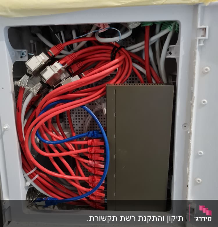 ארון תקשורת עם כבלים אדומים וכחולים מחוברים